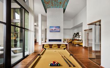 A large living room with a pool table and a fireplace